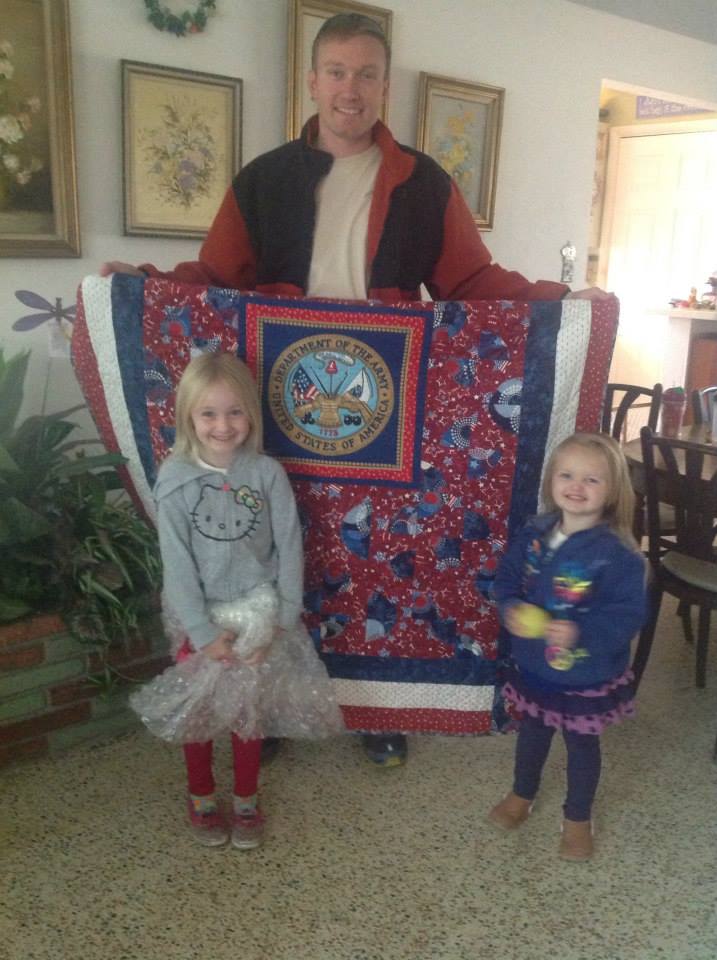 Troy Osten with his beautiful children and his Quilt of Valor