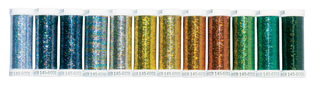 Four spools of shiny metallic thread in silver, gold, and bronze colors.