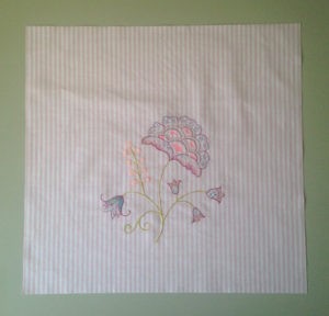 Embroidered floral design on striped fabric.