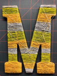 TIe off Threads Wrapped around Wooden Letter