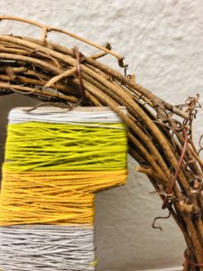 Letter Wrapped in Thread Secured by Wreath Branches