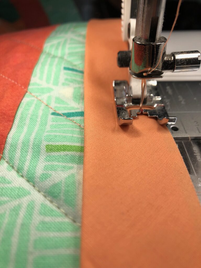 stitching binding to log cabin quilt