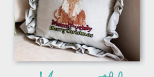 Christmas pillow with embroidered fox design.