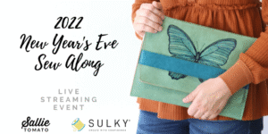 Person holding a butterfly-themed clutch bag.