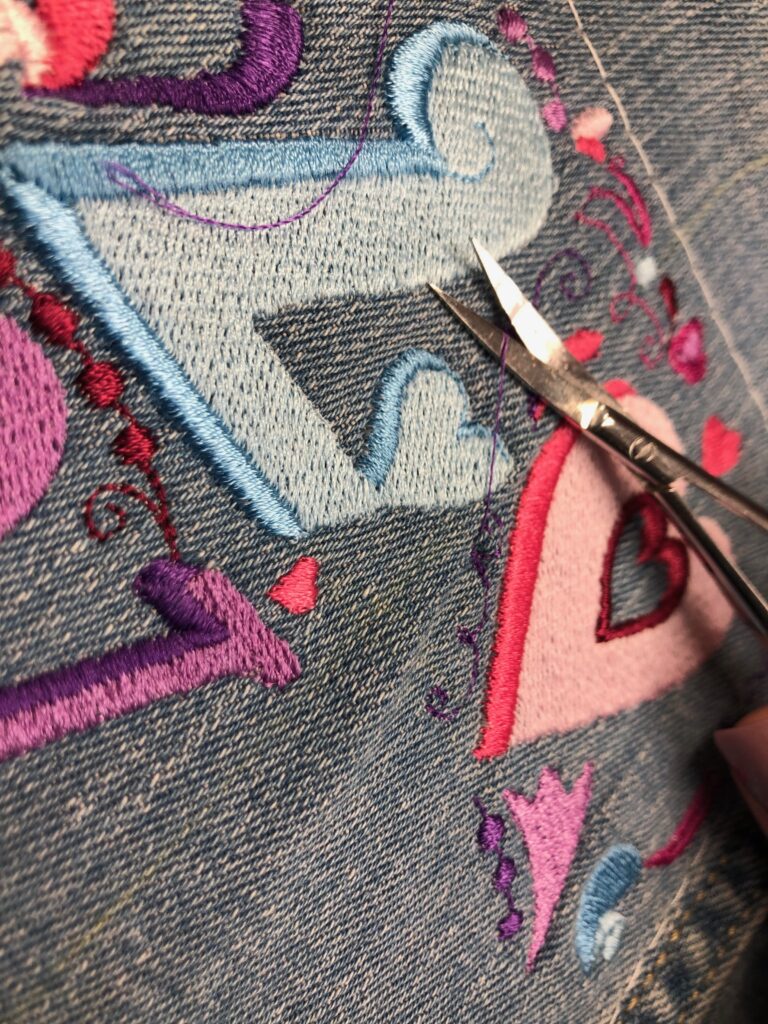 clipping jump threads on denim embroidery jacket