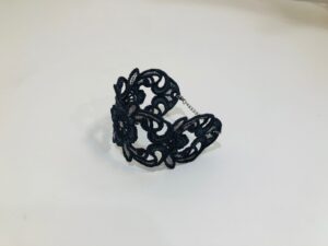 Intricately designed black lace ring with an elegant openwork pattern.
