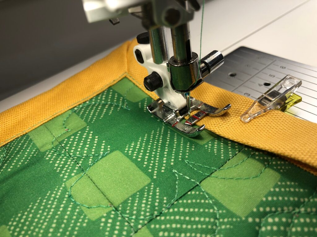 stitching binding of simple patchwork mini quilt