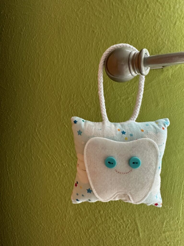 tooth fairy pillow hanging on hook with sunlight