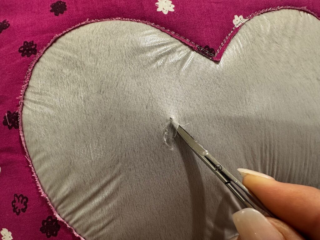 starting to remove Solvy stabilizer on fuzzy heart pillow