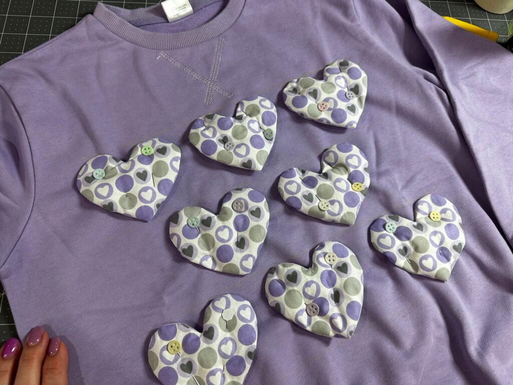 pinned heart appliques on sweatshirt