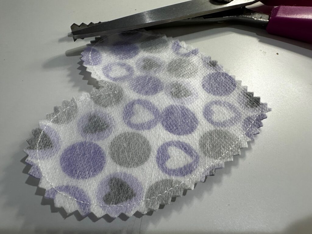 trimming puffy heart applique with pinking shears