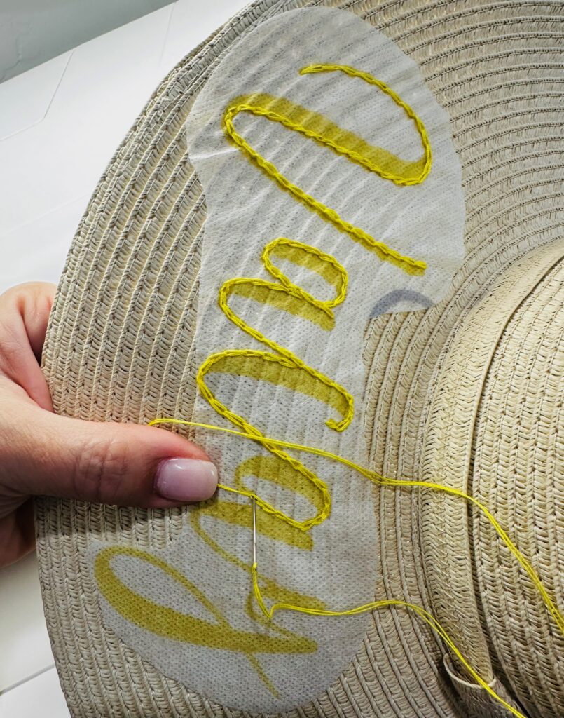 stitching a chainstitch to finish lettering on sunhat