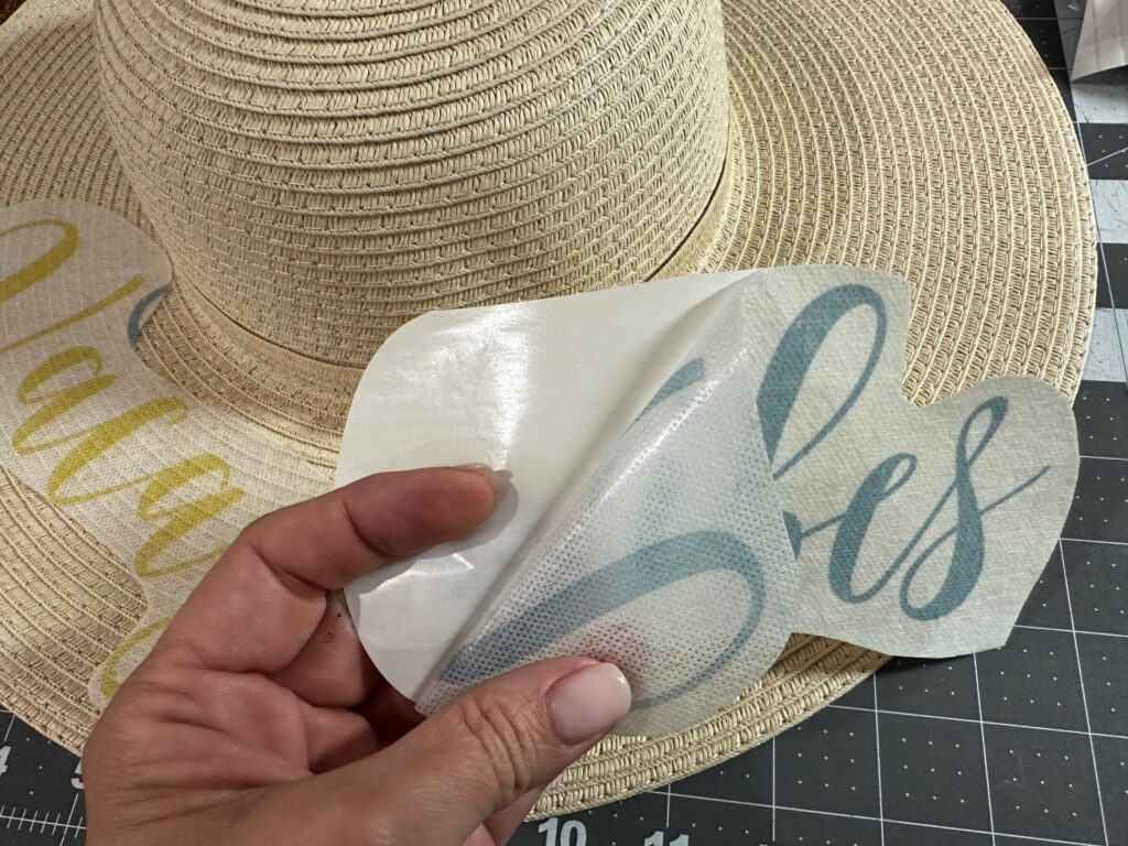 peeling off paper backing of Stick n Stitch Stabilizer to position transfer onto sunhat brim