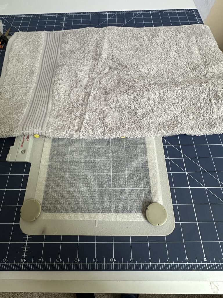 placing towel onto stabilizer in hoop