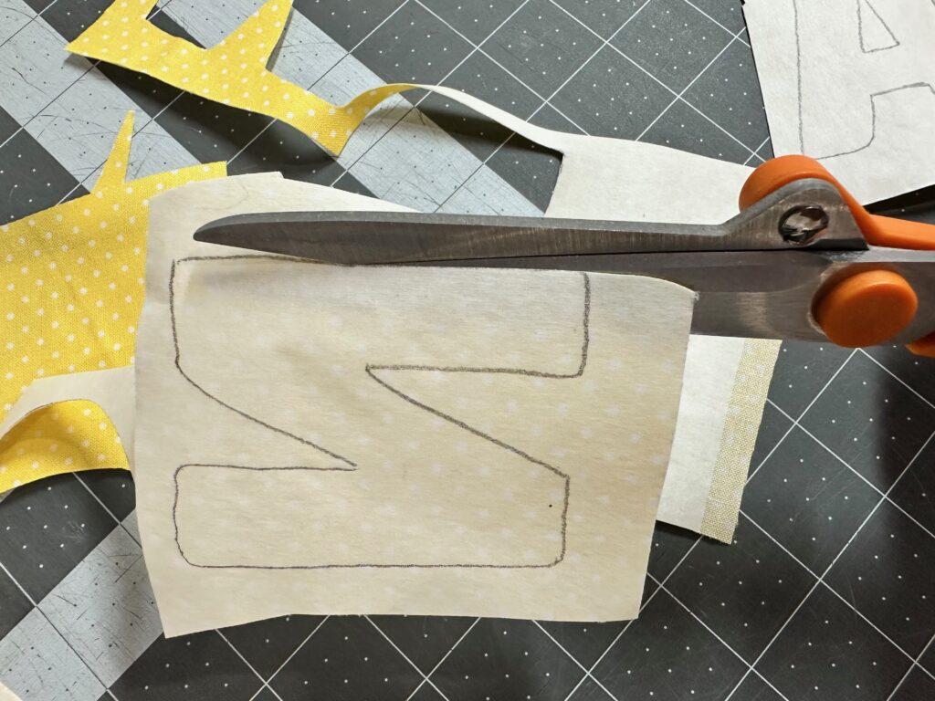 cutting out each letter to spell lemonade for applique