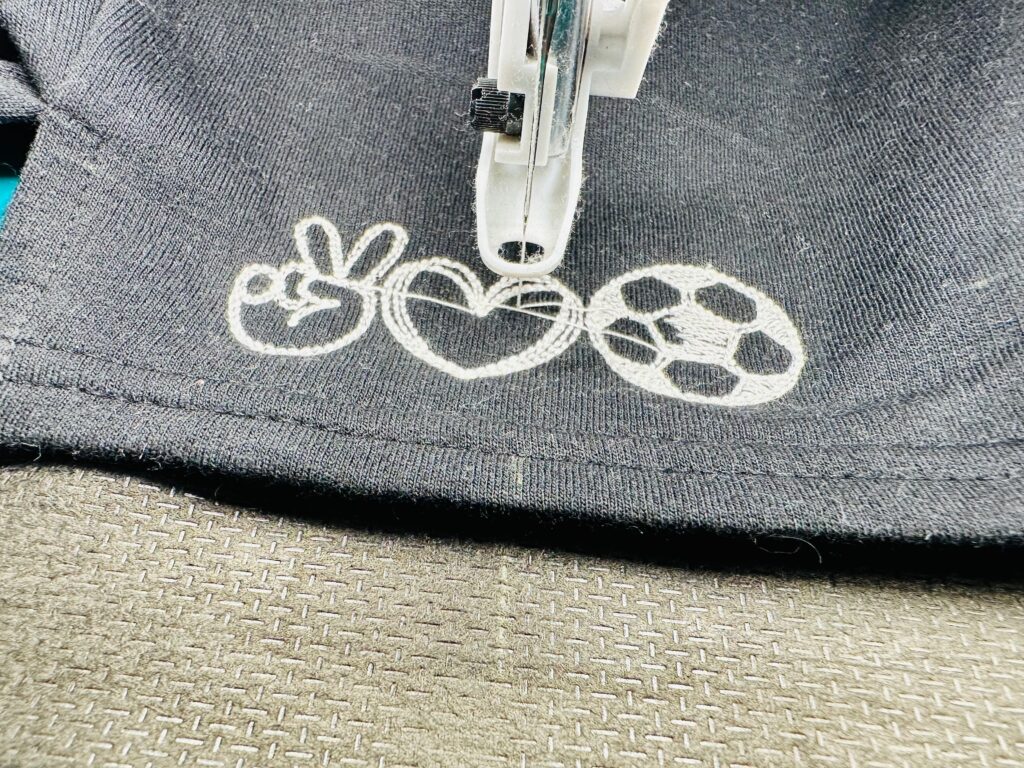 embroidering Peace Love Soccer design onto shorts