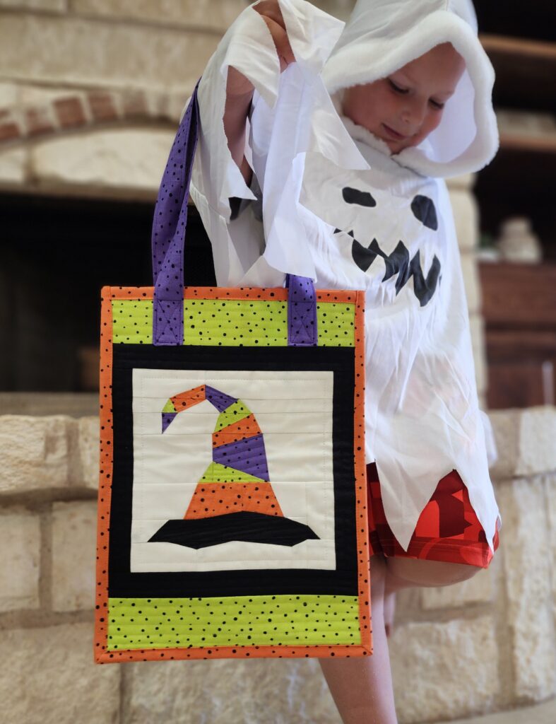 ghost kid holding witch tote