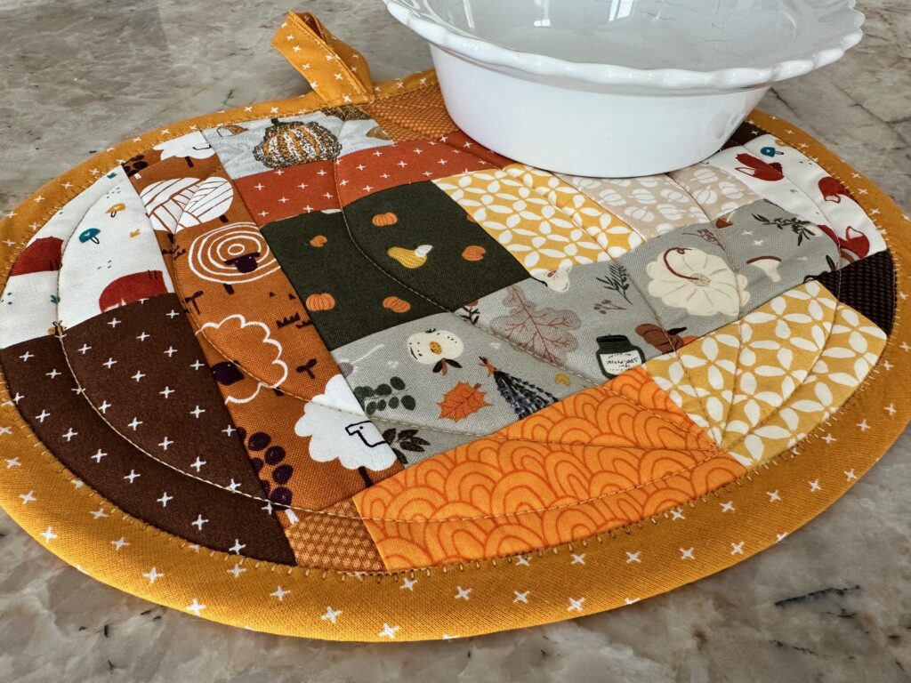 Scrappy Pumpkin Potholder on table with pie plate