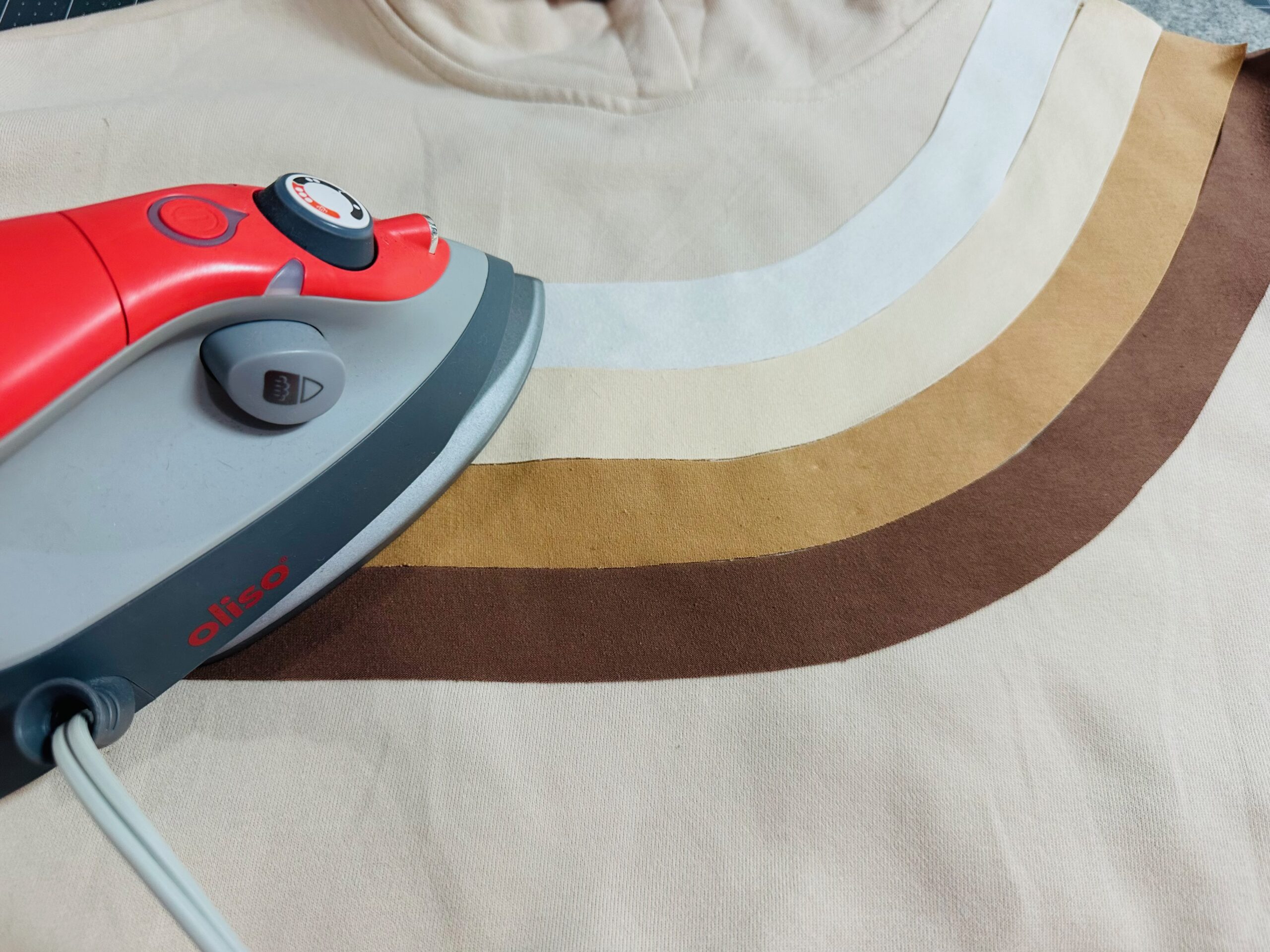 fusing stripe appliqués in place on sweatshirt