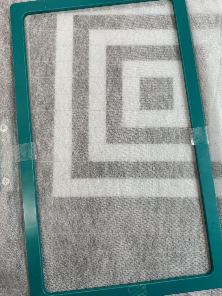 Smiling woman with short brown hair wearing a black top and pearl necklace.