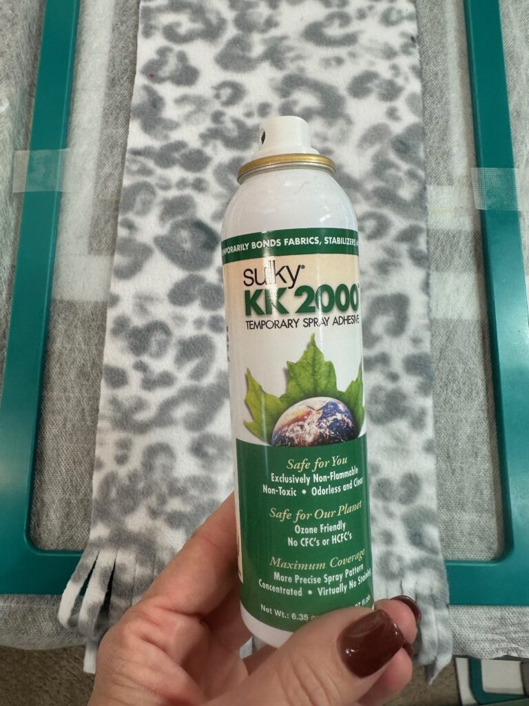 Smiling woman with short brown hair wearing a black top and pearl necklace.