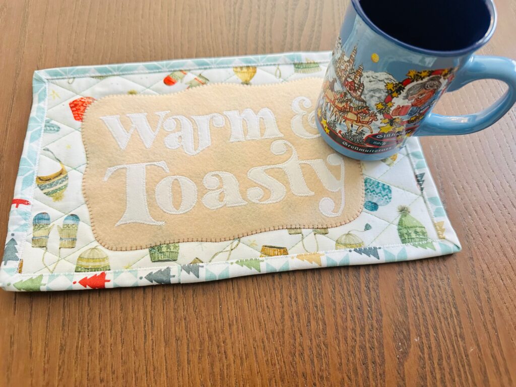 Warm and Toasty Appliqué Mug Rug with mug on table