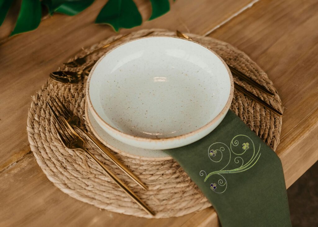 four leaf clover design on dark green napkin on table setting