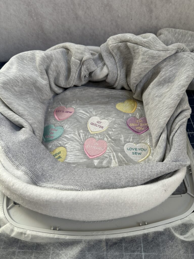 finished designs and sweatshirt still in hoop