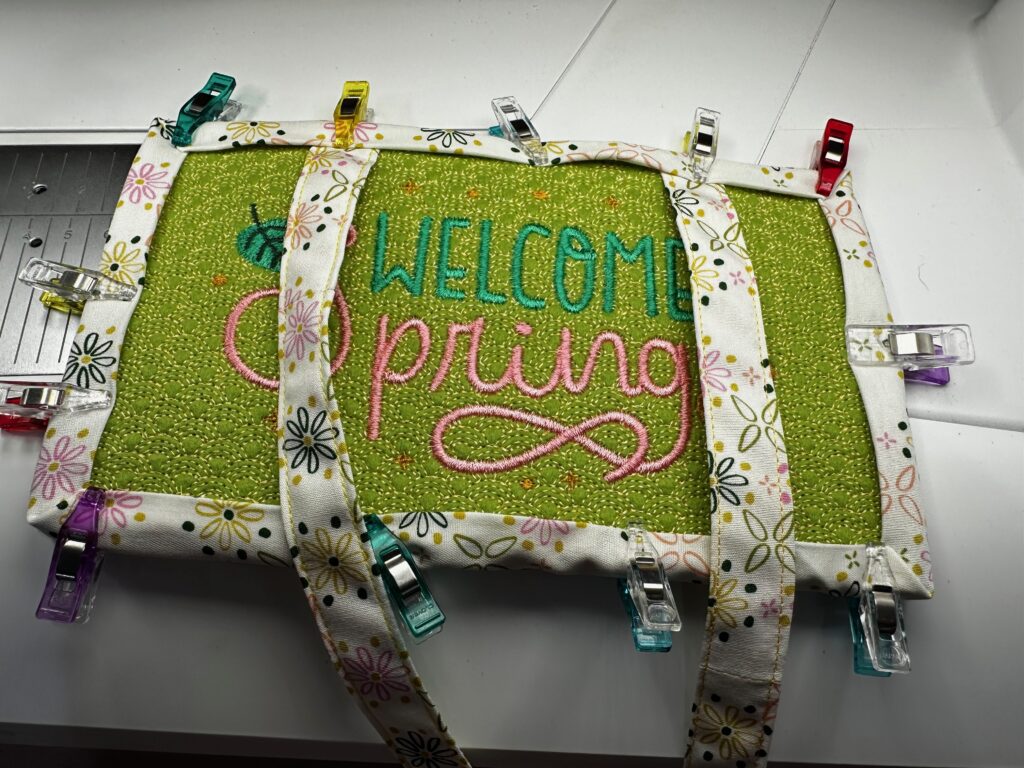 binding welcome spring sign with ties extending