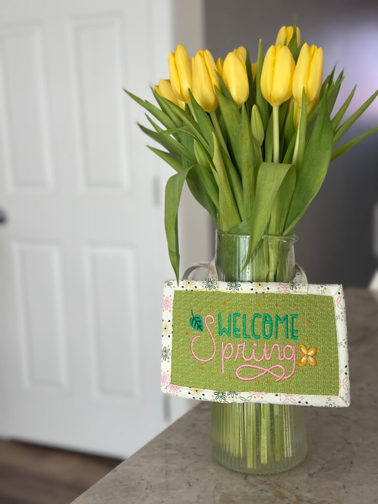 welcome spring sign on vase