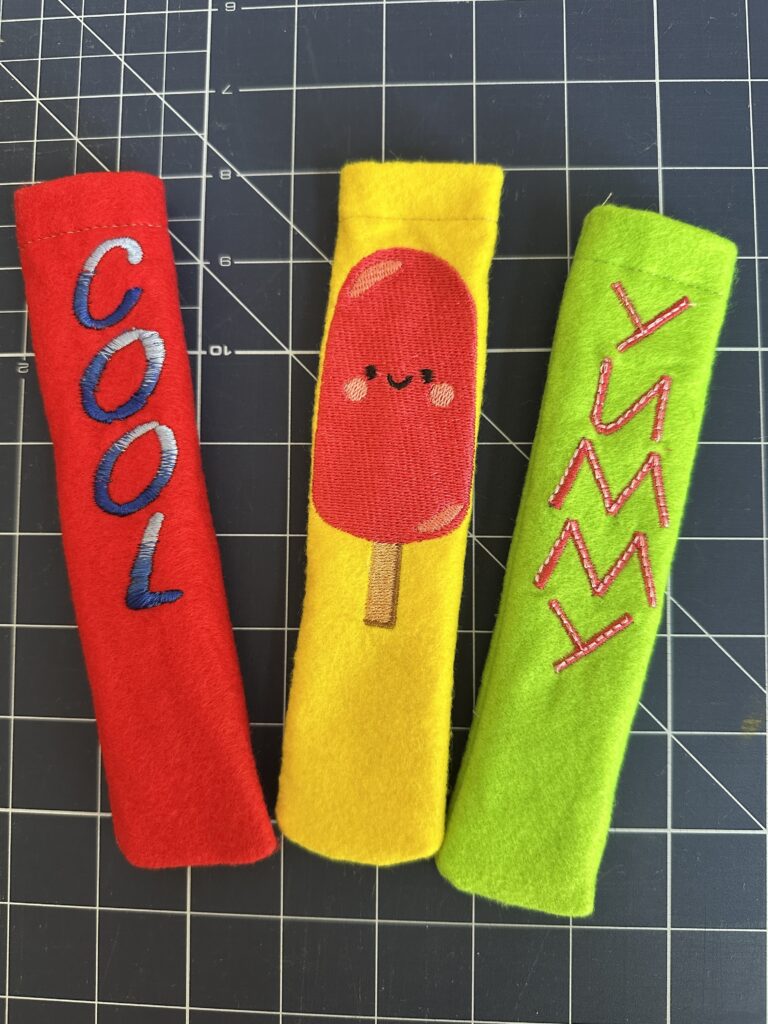 three finished popsicle koozies