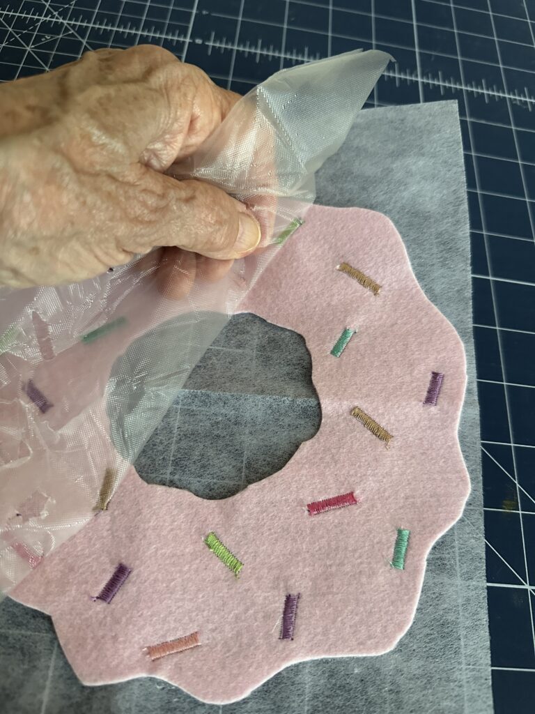 tearing away Solvy on donut icing right side