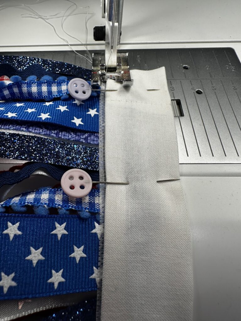 stitching lower edge of casing to secure ribbon ends