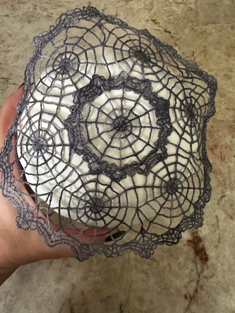 placing doily on pumpkin