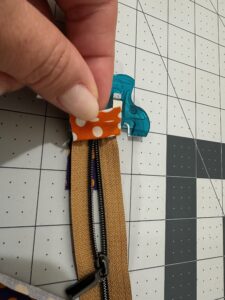sandwiching zipper between two zipper tabs