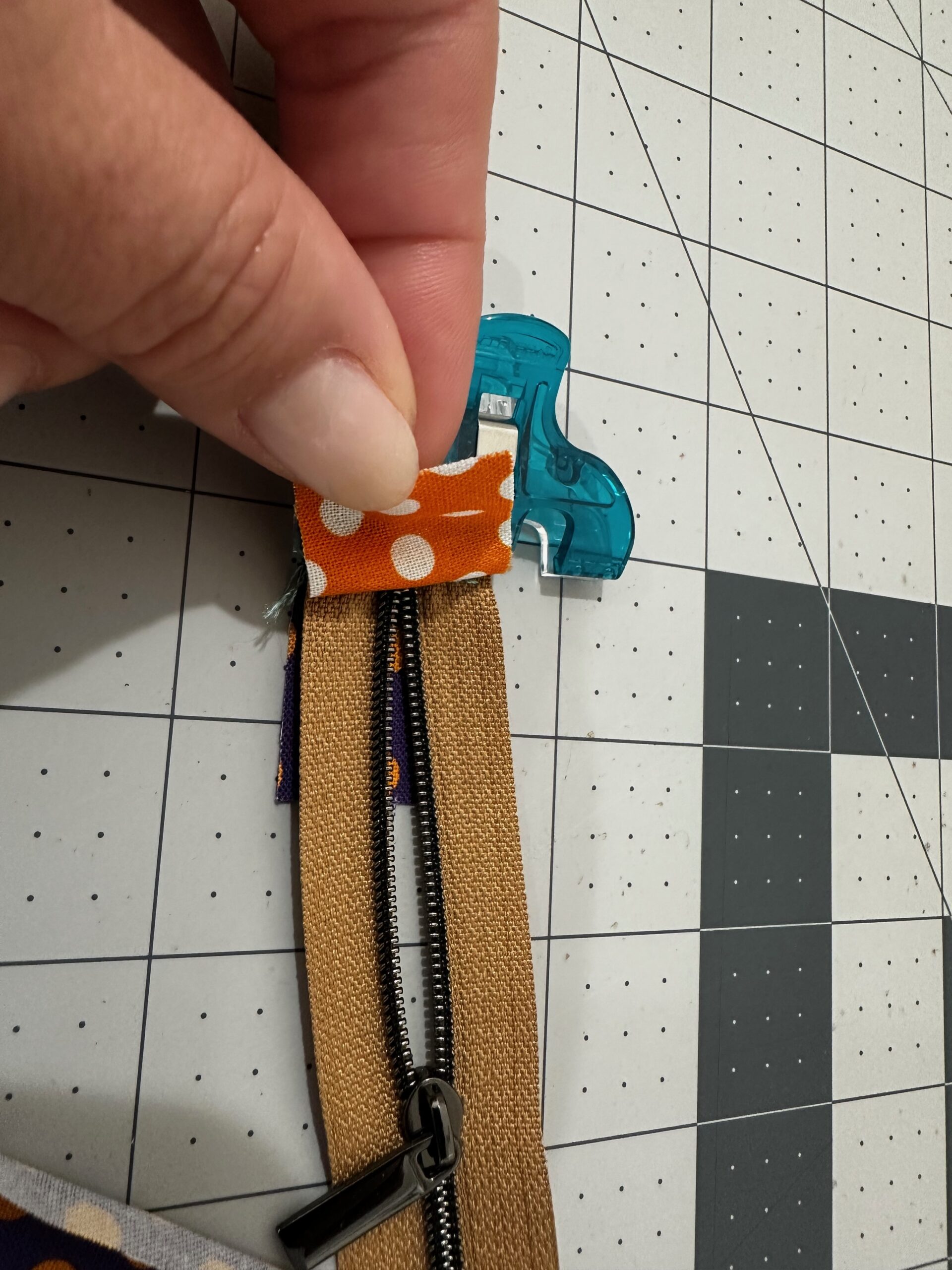 sandwiching zipper between two zipper tabs